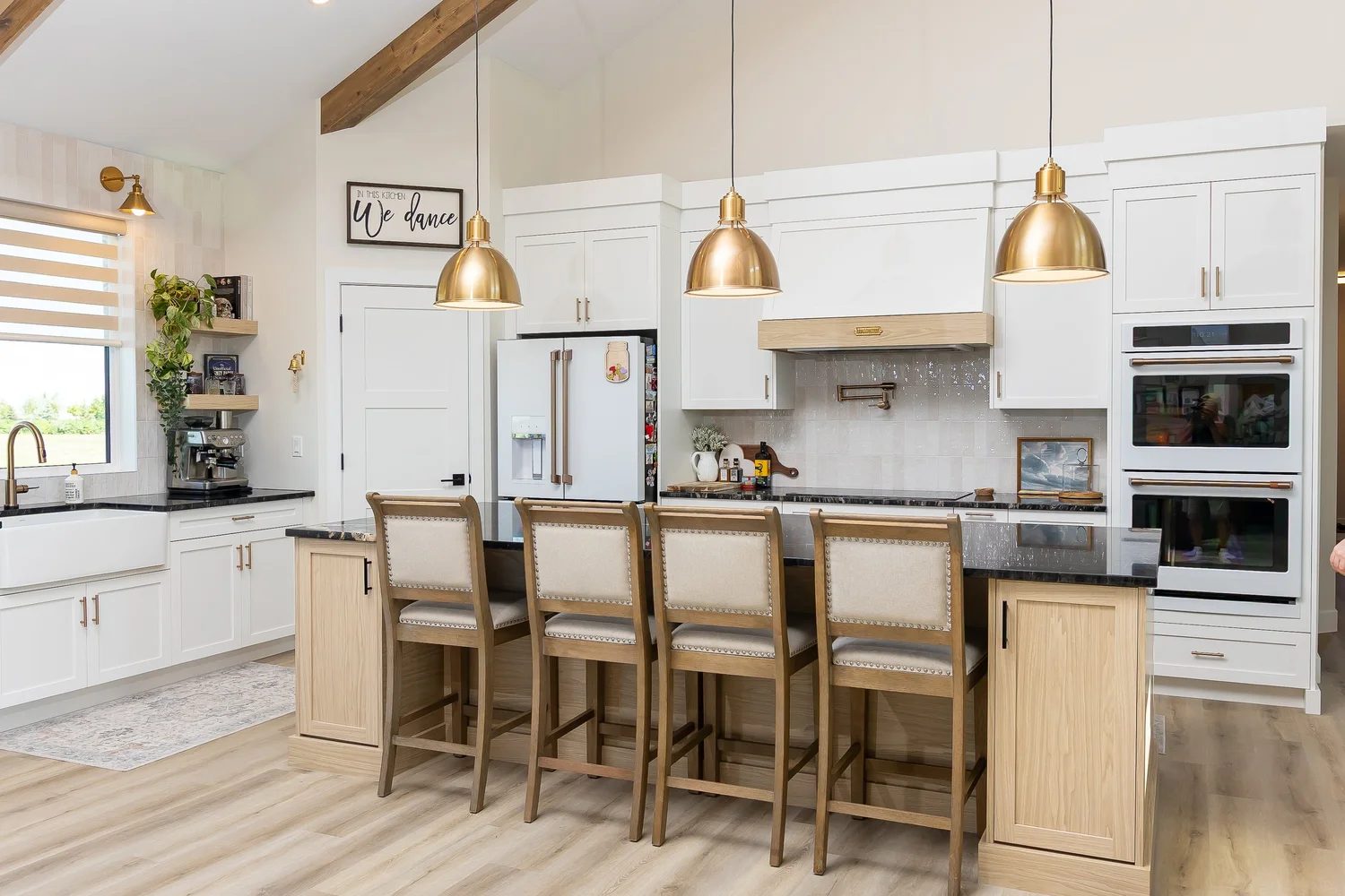 Bright white custom kitchen with island seating and pendant lights